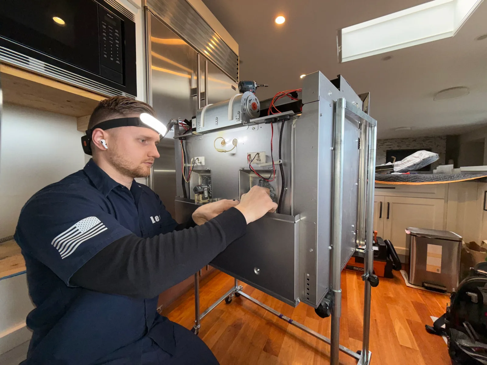 Expert Appliance Repair technician servicing a built-in appliance in a King County kitchen